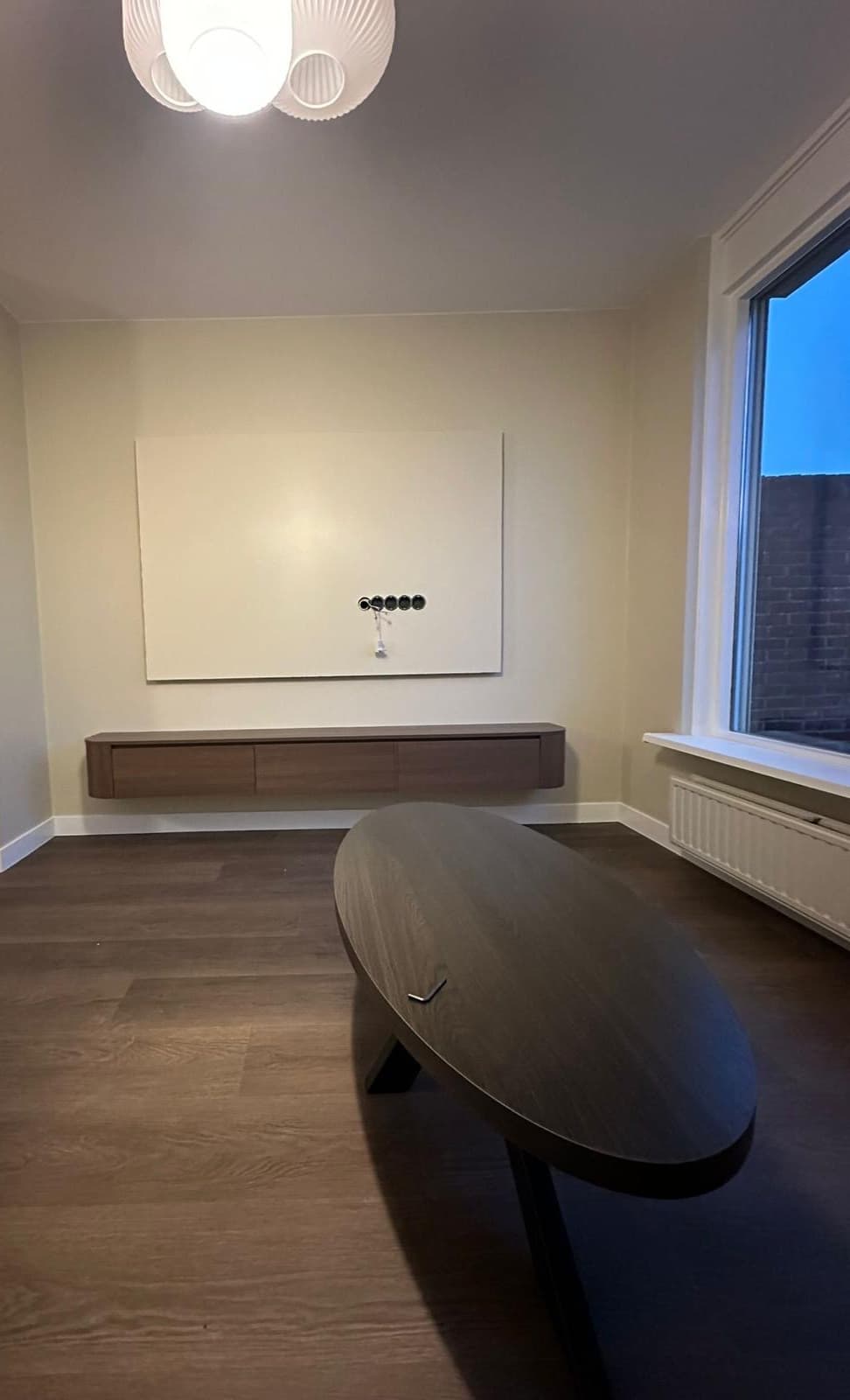 Woonkamer met zwevend eiken tv-meubel, wandpaneel en donkere houten vloer — Vesta Lux project in Zeeland