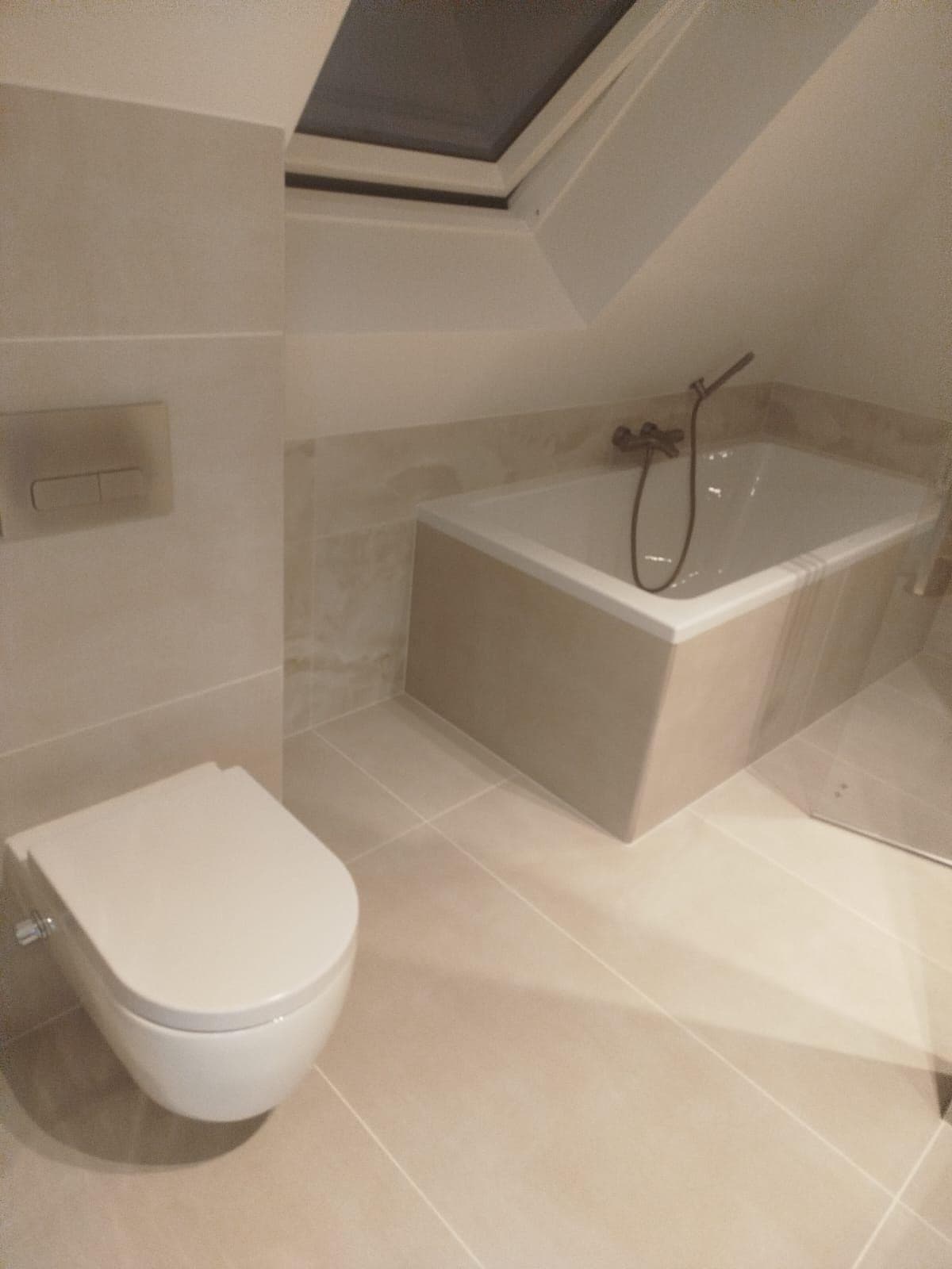 Ligbad met handdouche en hangend toilet, dakraam met verduisteringsscherm en beige tegels — Vesta Lux project in Zeeland