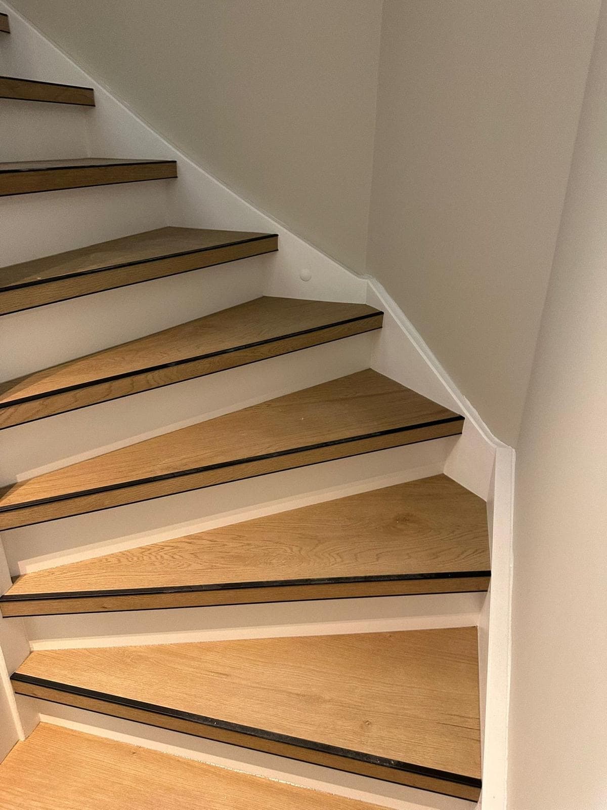 Maatwerk houten trap met winder-treden tegen strak wit stucwerk — Vesta Lux project in Zeeland
